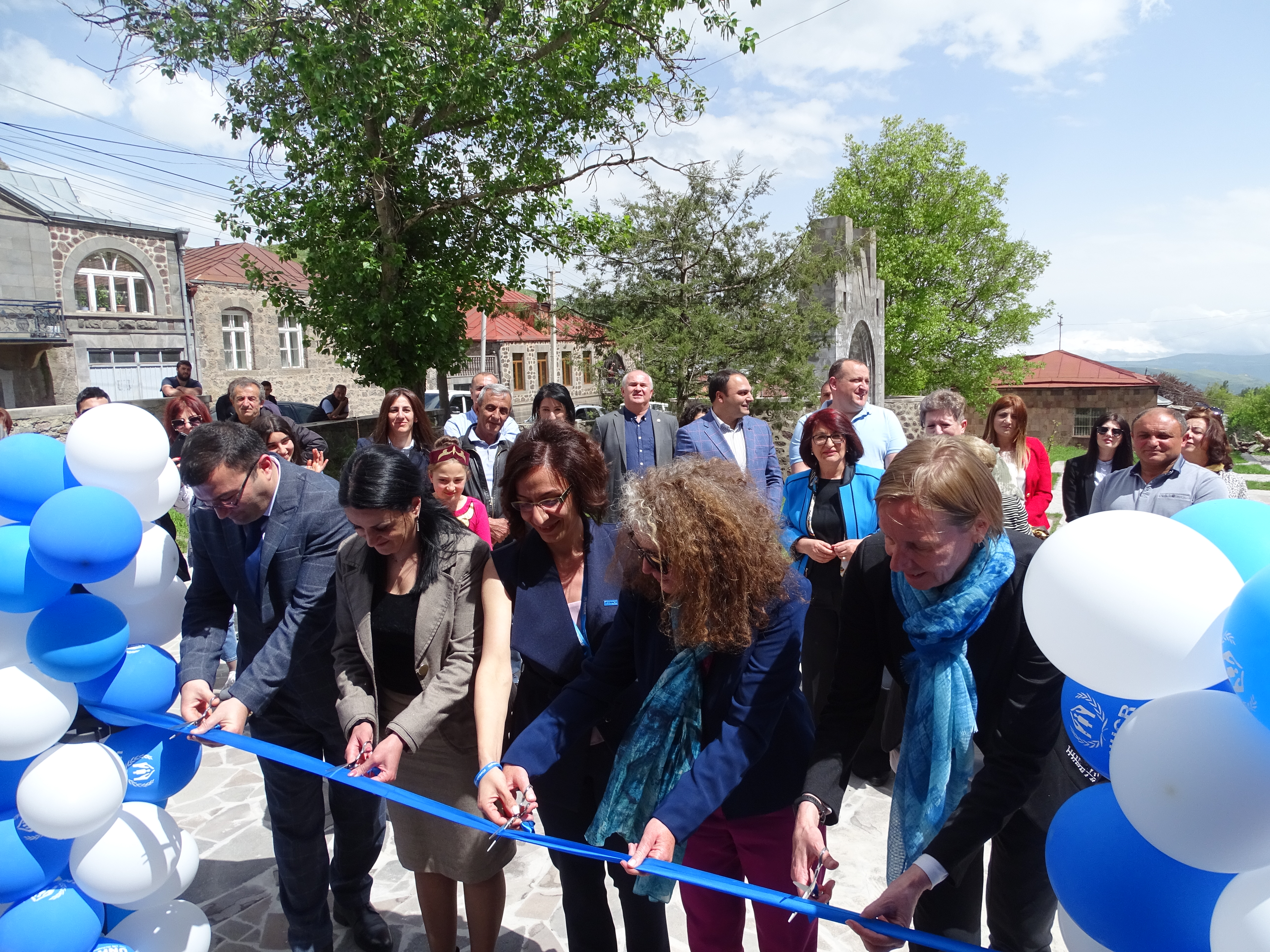 Five officials cutting the ribbon during the opening ceremony of the UNHCR Goris Field Unit office.