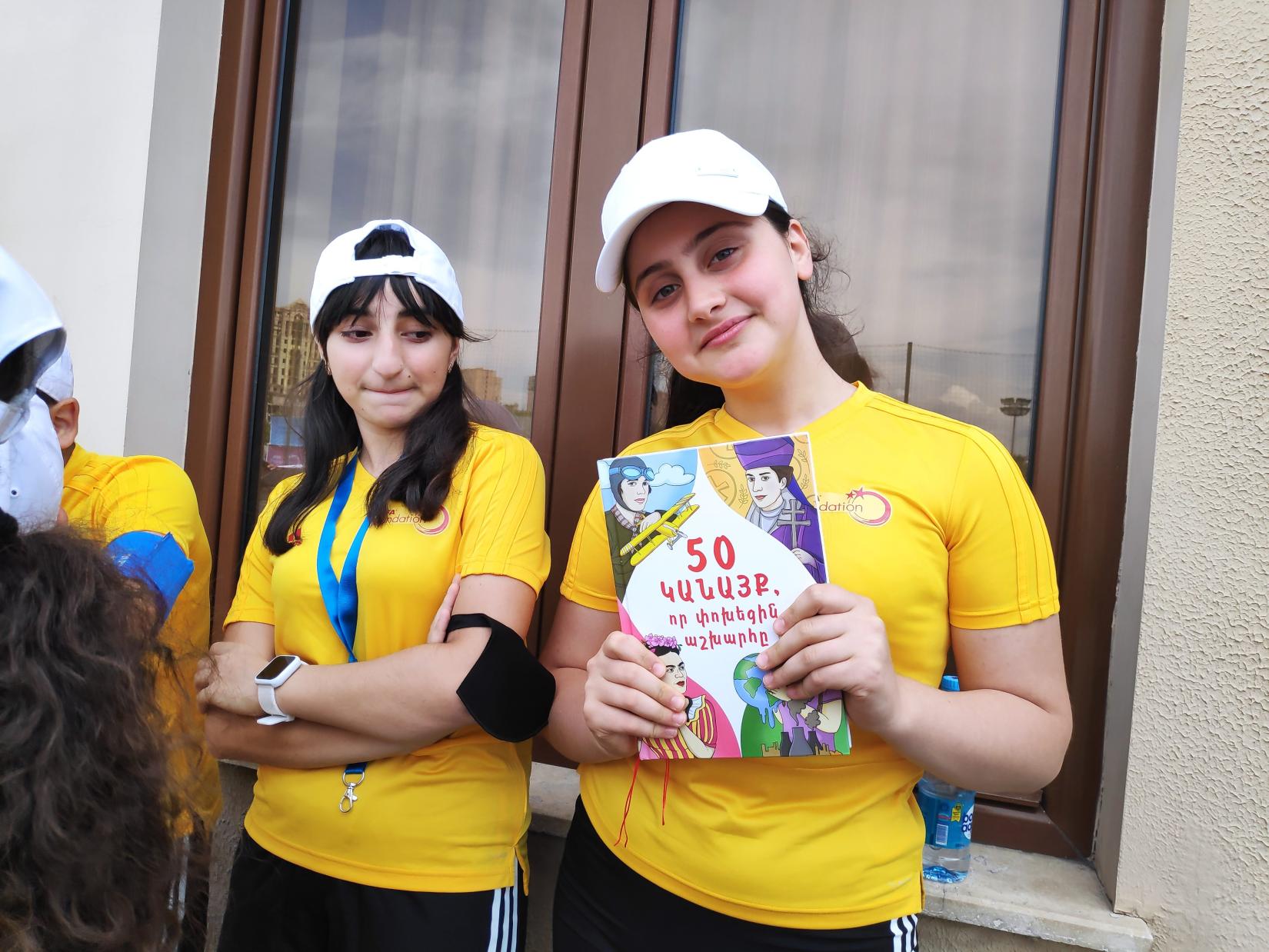 A girl showcases her copy of "50 Women that Changed the World" book.