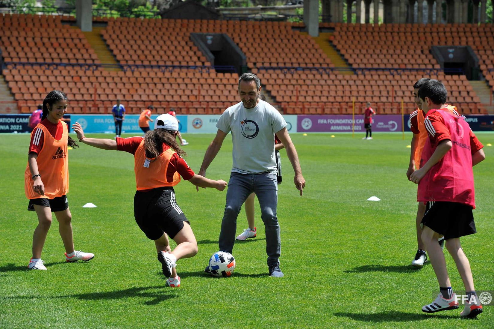 Youri Djorkaeff plays football with Campus participants.