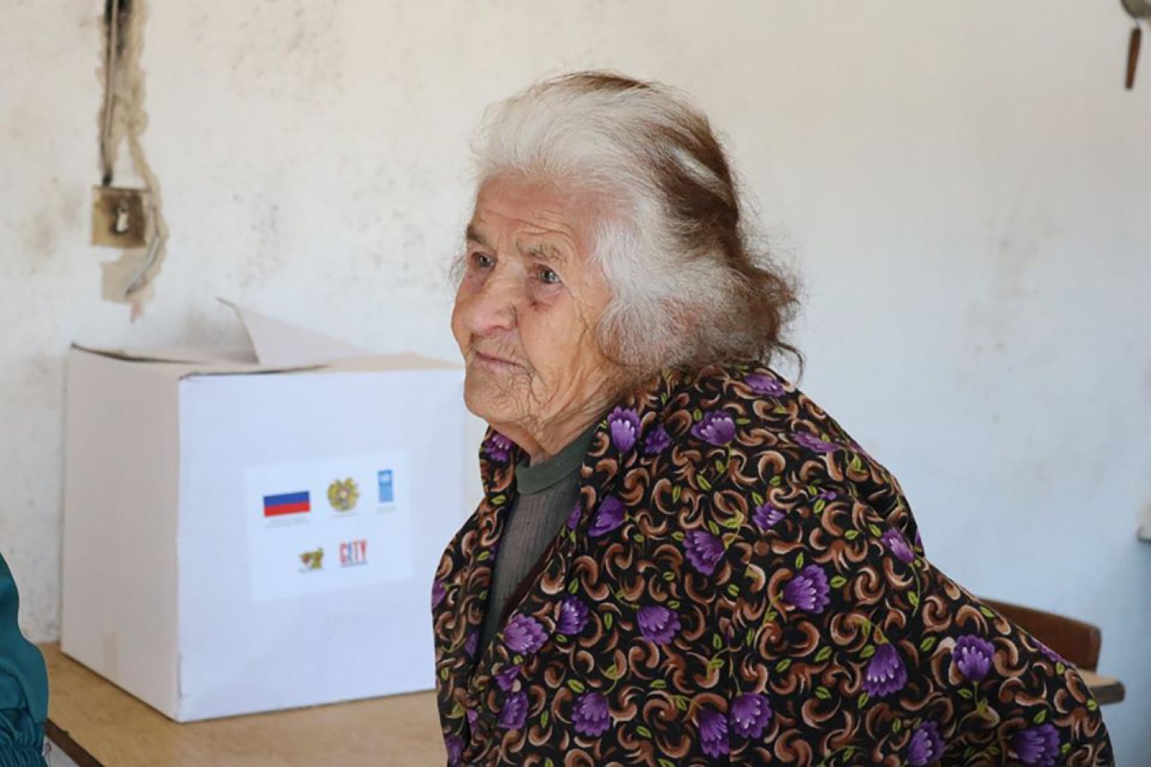 Elderly woman with emergency food package.