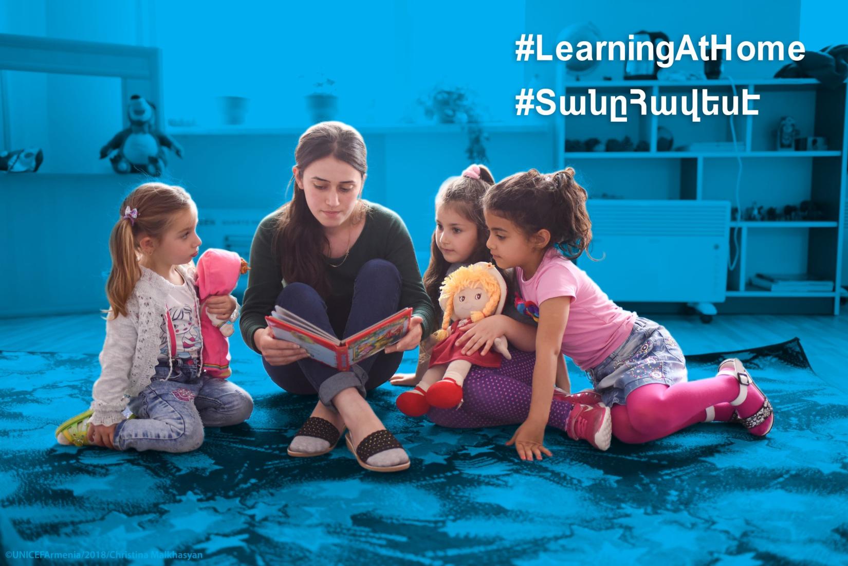 A young woman reads a book to children.