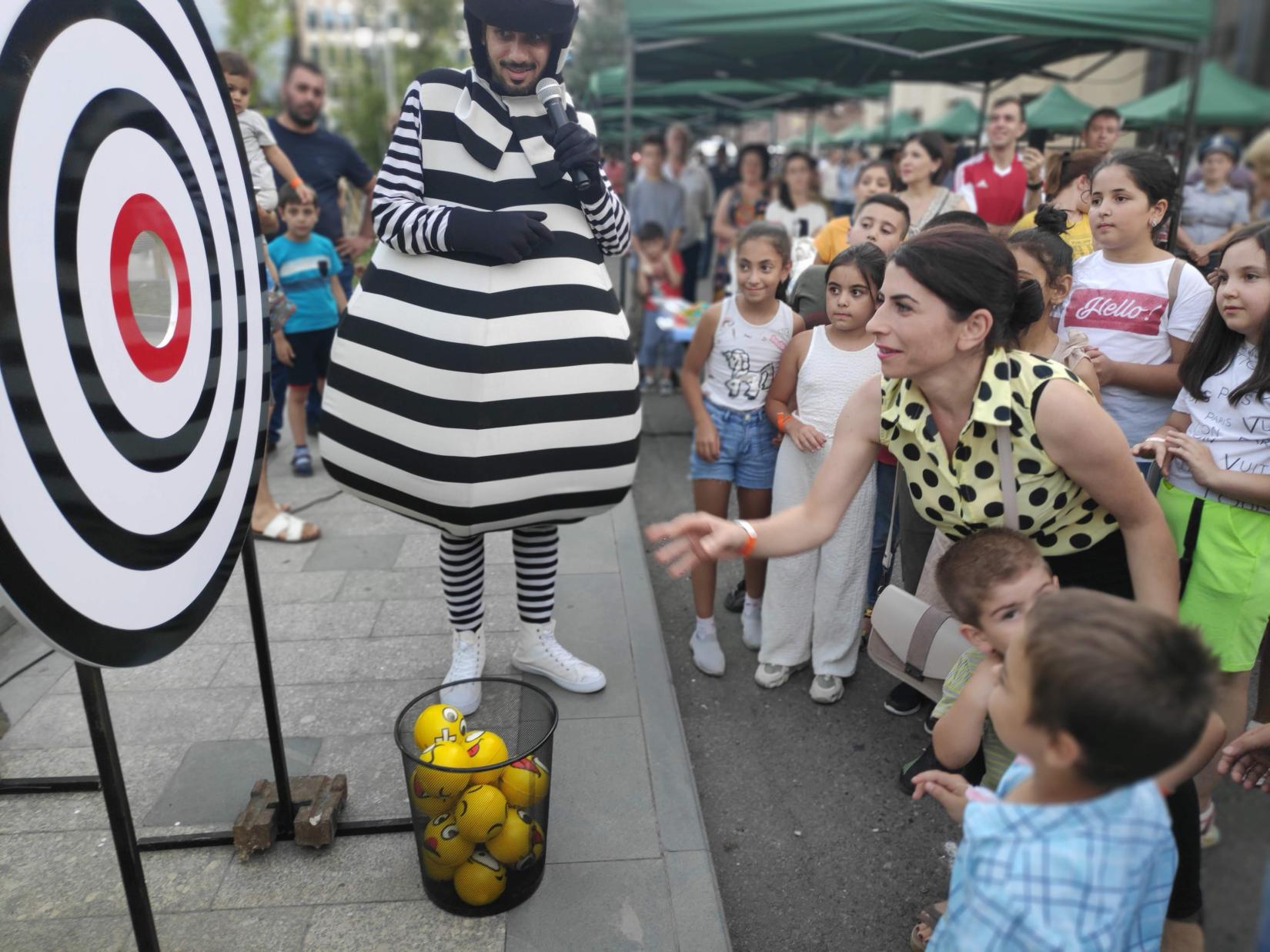 A woman participating in the "Save the Planet SDGs" fun and educational Zebra Game throws a ball into the target.