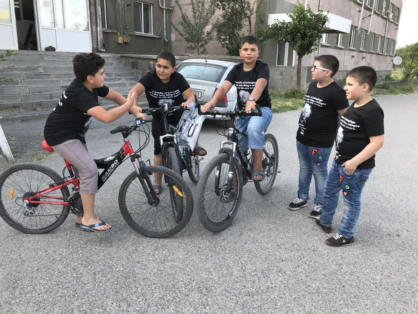 A group of young bikers gathered for an important discourse in their Albert Einstein T-shirts.