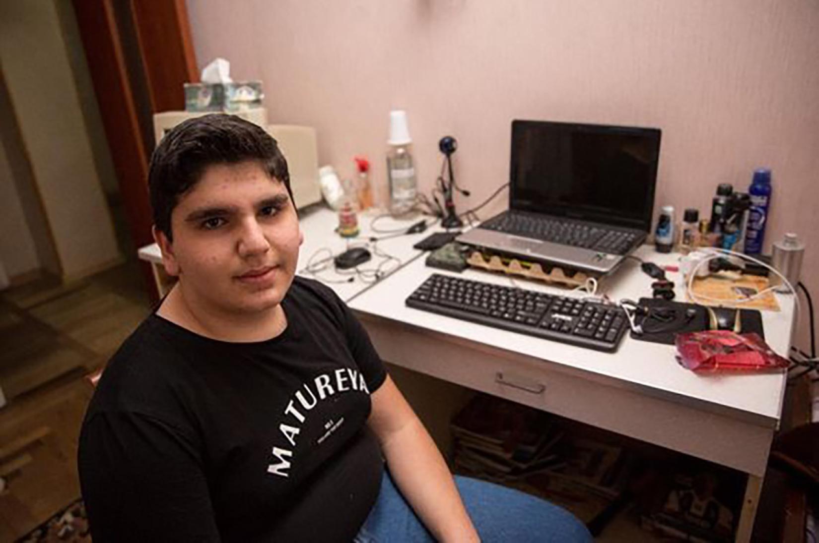 Matevos sitting next to his computer. 