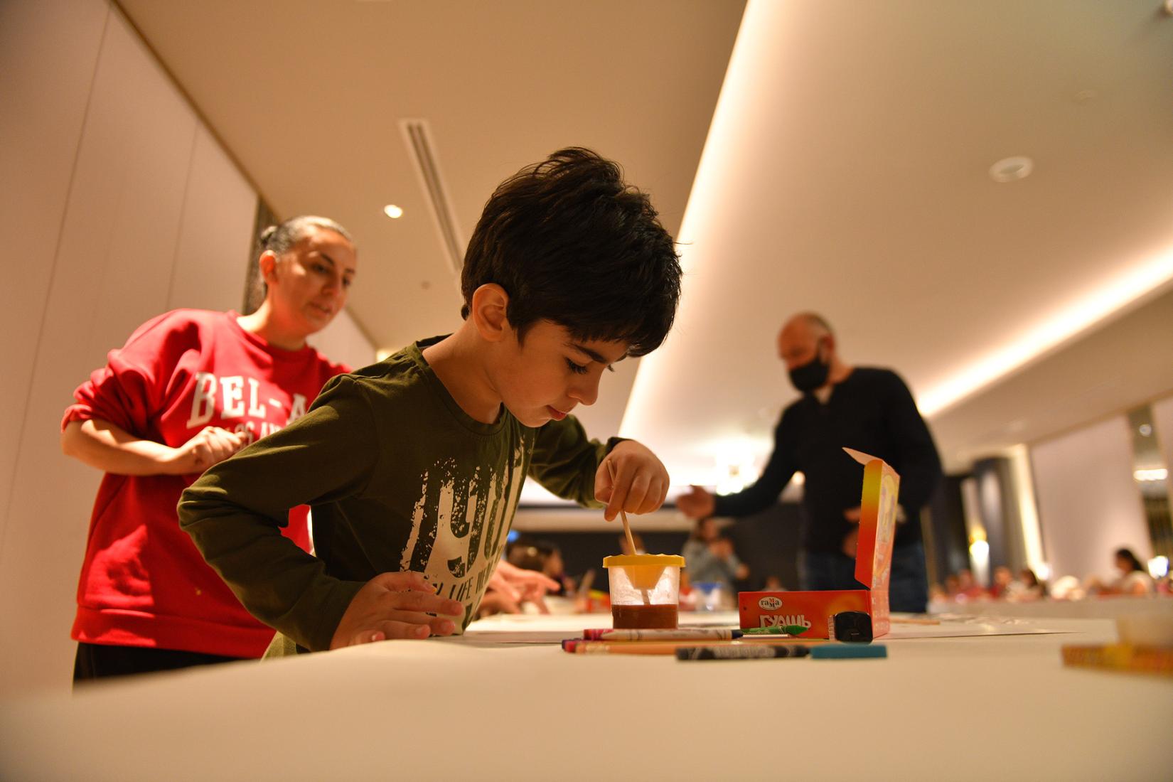 A young boy painting during the event.