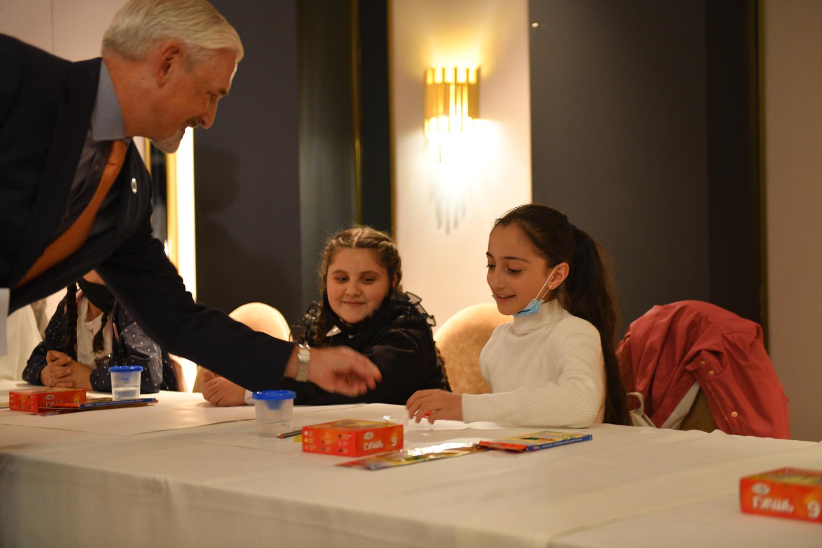 UN Resident Coordinator in Armenia gives a symbolic gift to a girl.
