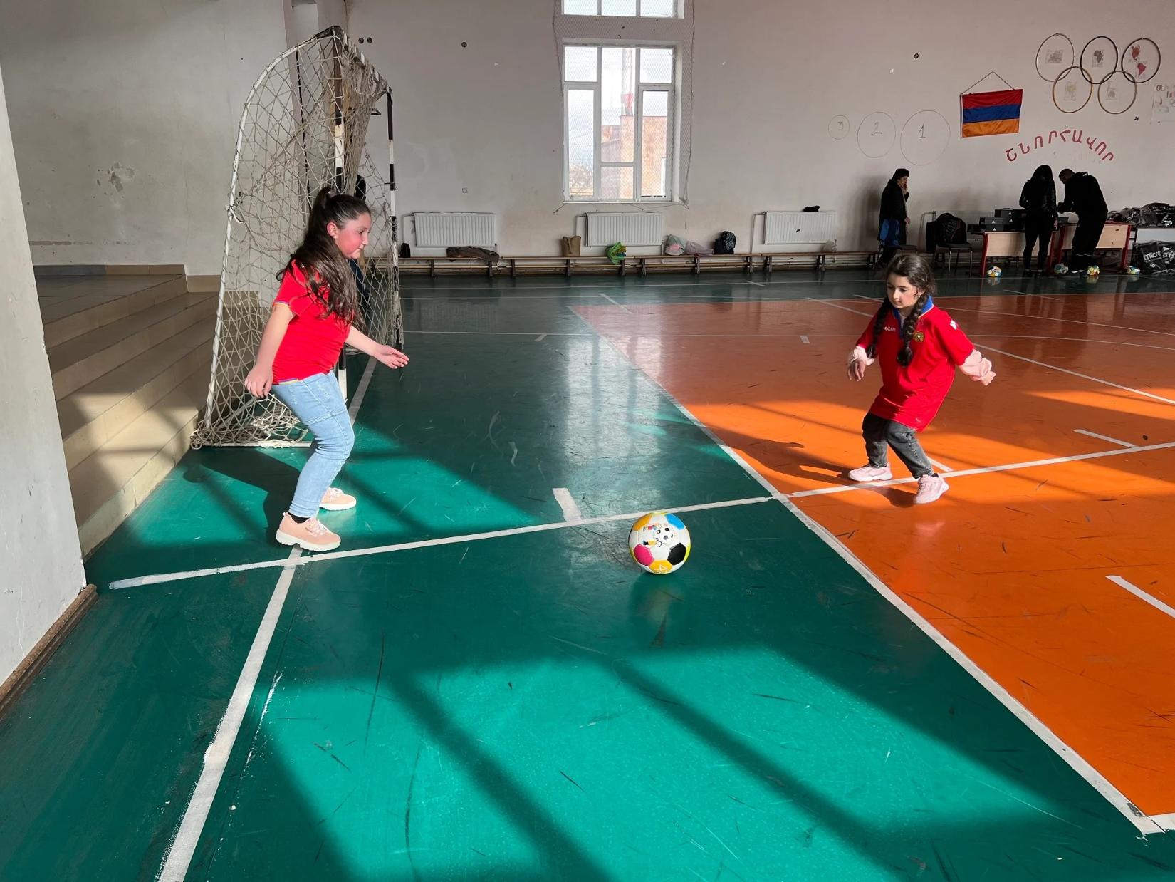 Two girls playing football.