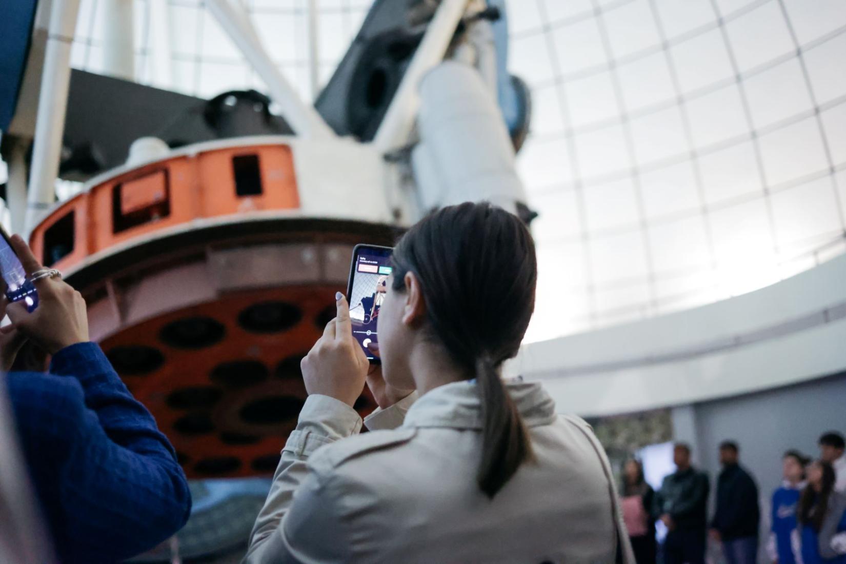 A girl takes a photo of 2.6 m telescope-the largest observational instrument of BAO.   