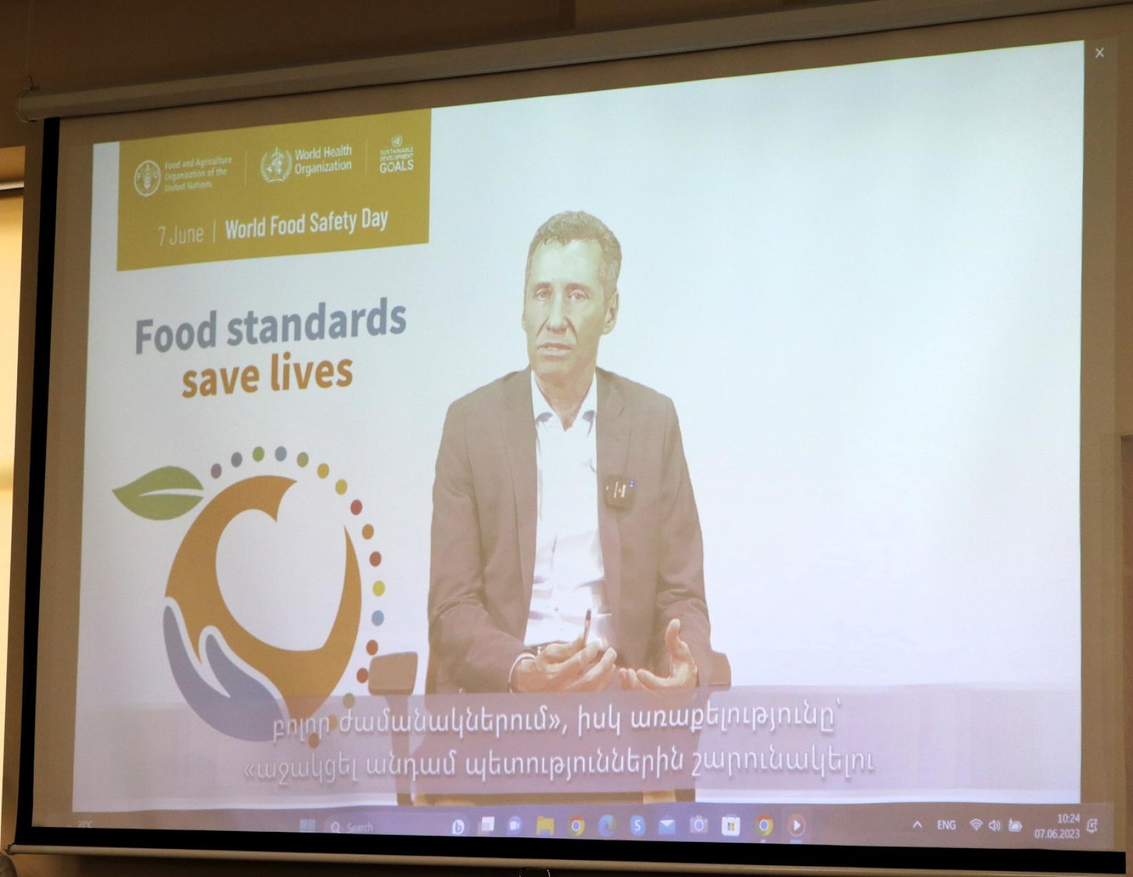 A screen photo of a male FAO Representative delivering a speech on World Food Safety Day.