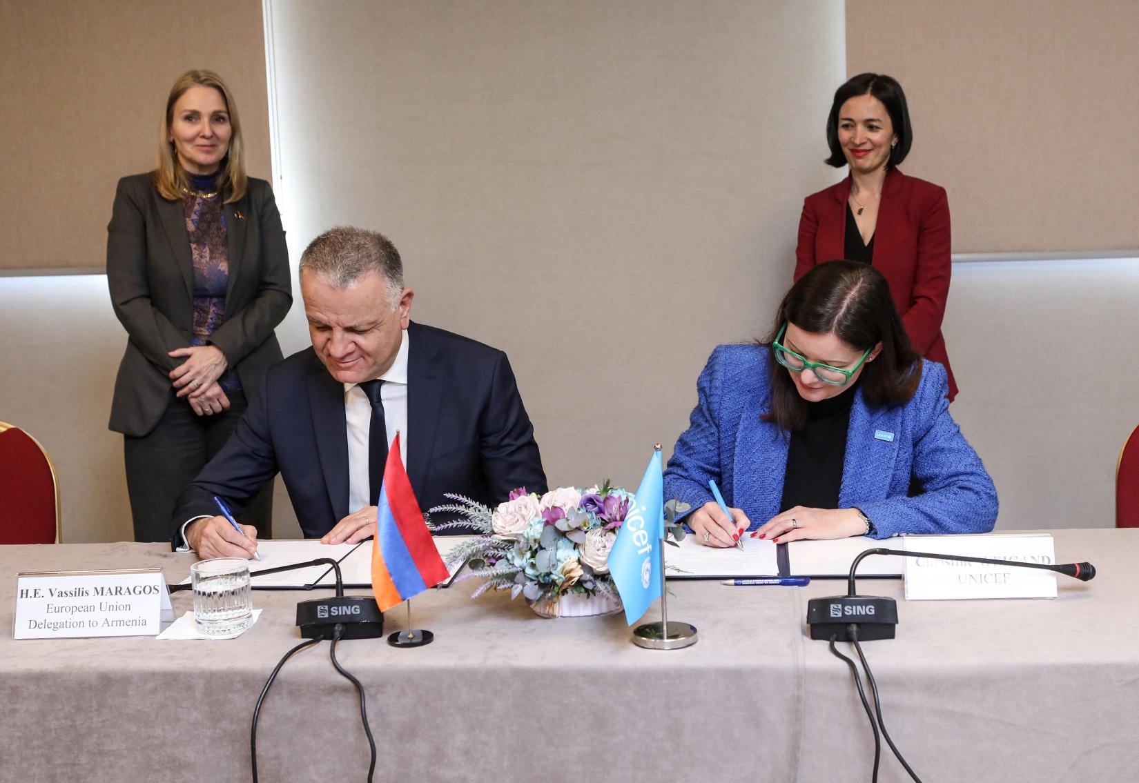 EU and UNICEF officials signing an agreement.