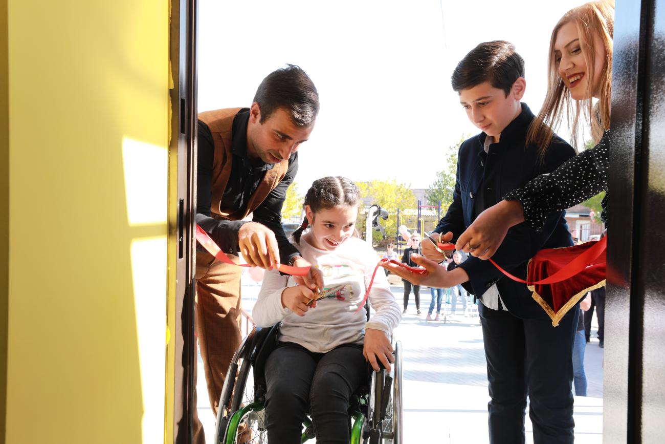 A young girl with a disability and a boy cut the ribbon of the new inclusive youth center in Gyumri.