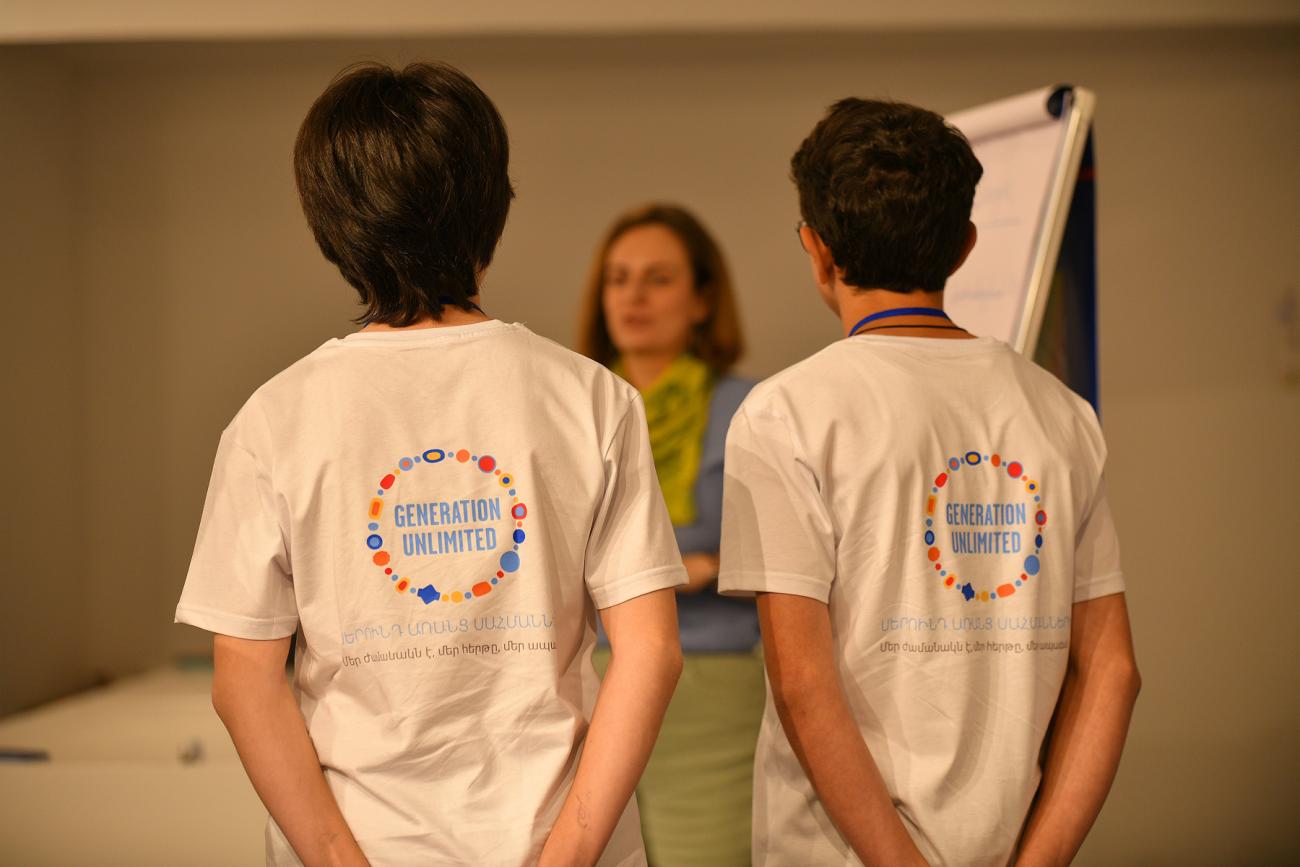 Two participants wearing white T-shirts and a mentor during the bootcamp phase of GenU challenge.