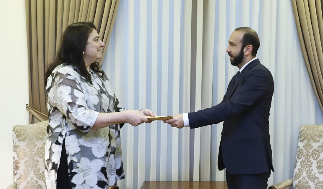 A woman official handing over the letter of accreditation to the Minister of Foreign Affairs.