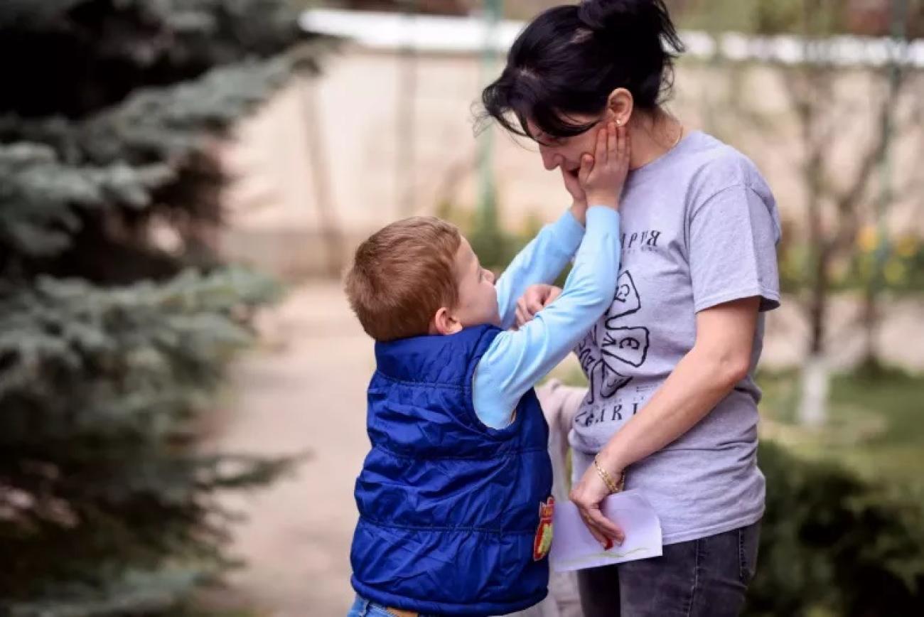 Little boy stroking gently his mother.