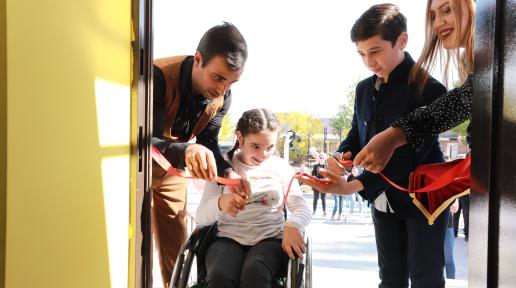 A young girl with a disability and a boy cut the ribbon of the new inclusive youth center in Gyumri.