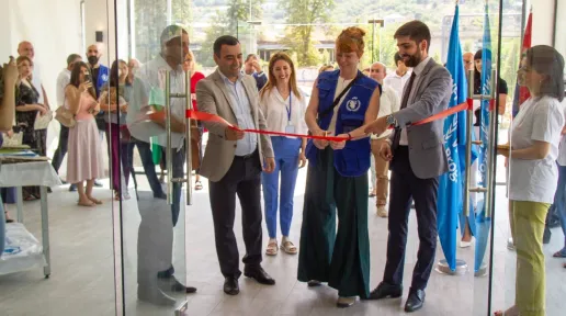 Attendees cutting the red ribbon.