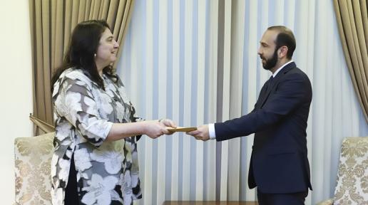 A woman official handing over the letter of accreditation to the Minister of Foreign Affairs.