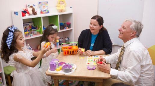 Two adults playing with two kids.