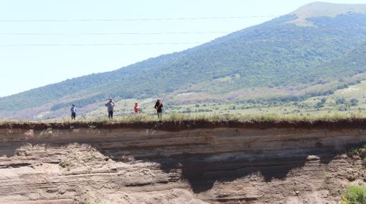 Four people in a degraded pasture.