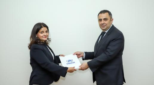 A woman is handing over her letter of accreditation to the Foreign Ministry.